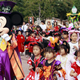 Children in Halloween costumes stand next to Mickey Mouse at Tokyo Disneyland.